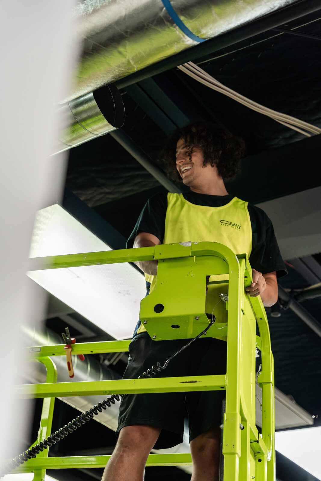 Electrician working from elevated platform on commercial site